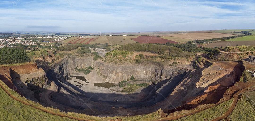 Fotos Tratores e caminhões removendo pedras de dentro de um buraco de pedreira