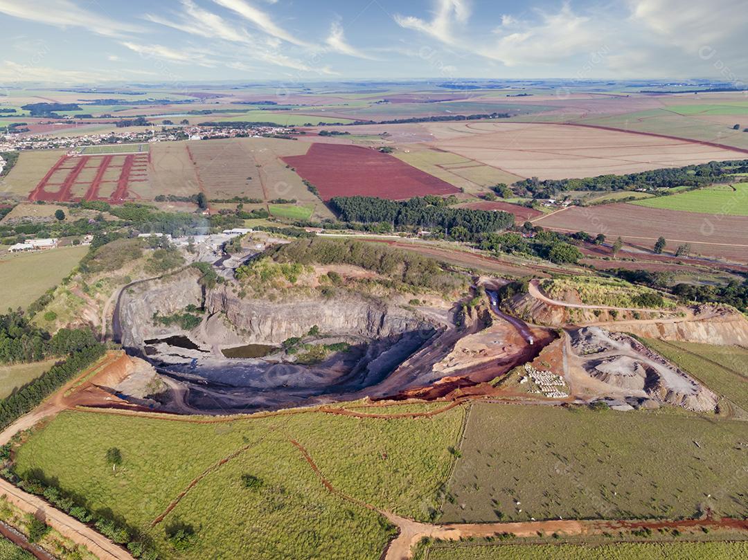 Fotos Tratores e caminhões removendo pedras de dentro de um buraco de pedreira