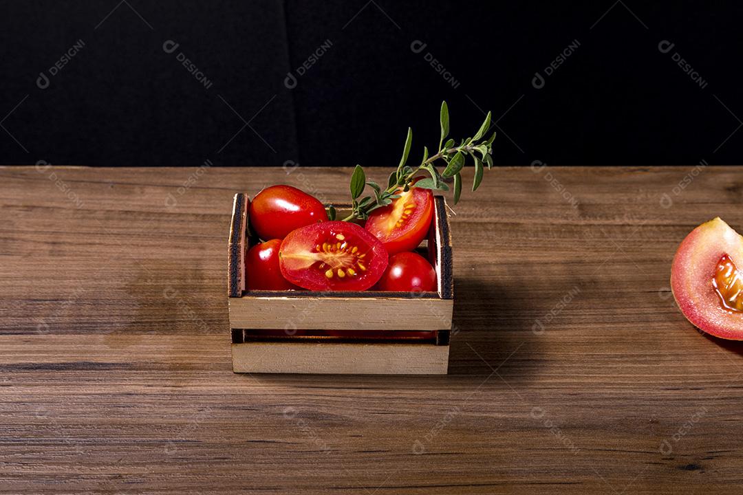 caixa de madeira com tomate e galho de orégano.Imagem JPG