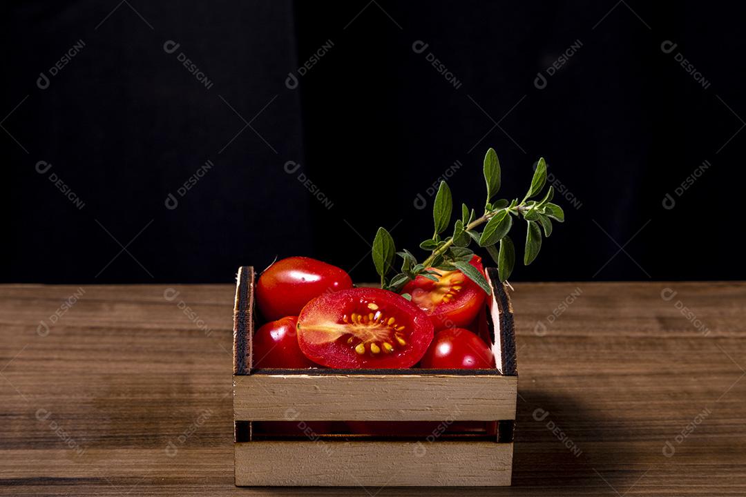 caixa de madeira com tomate e galho de orégano.Imagem JPG
