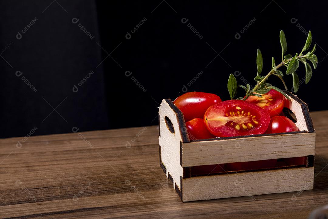 caixa de madeira com tomate e galho de orégano.Imagem JPG