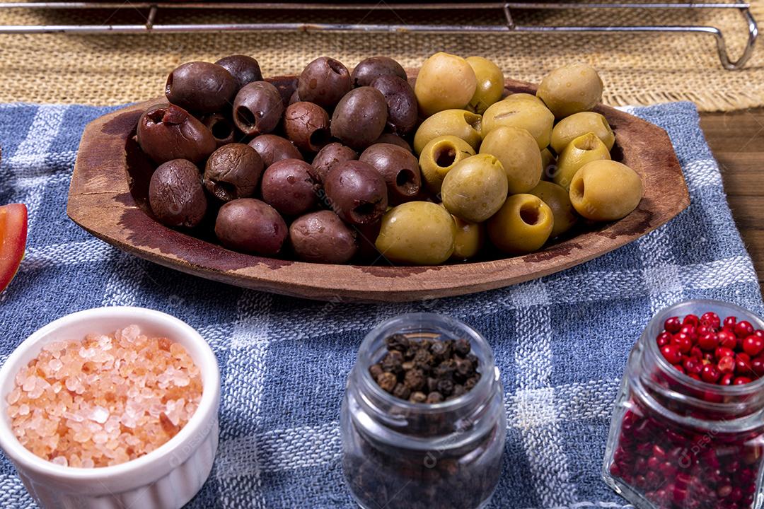 Fotos Porção de azeitonas pretas e verdes, tigela com sal rosa do Himalaia e frascos de vidro