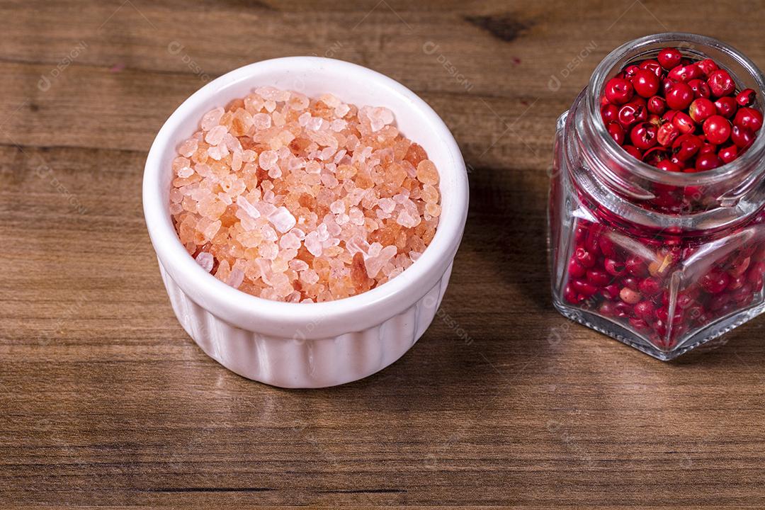 Fotos Closeup na tigela com sal do Himalaia rosa e frasco de vidro com pimenta vermelha