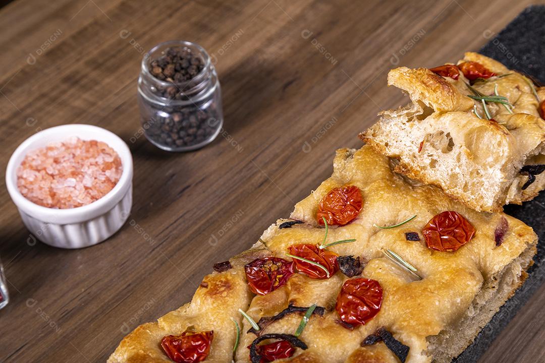 Fotos Focaccia tradicional italiana com calabresa, tomate cereja, azeitonas pretas, alecrim