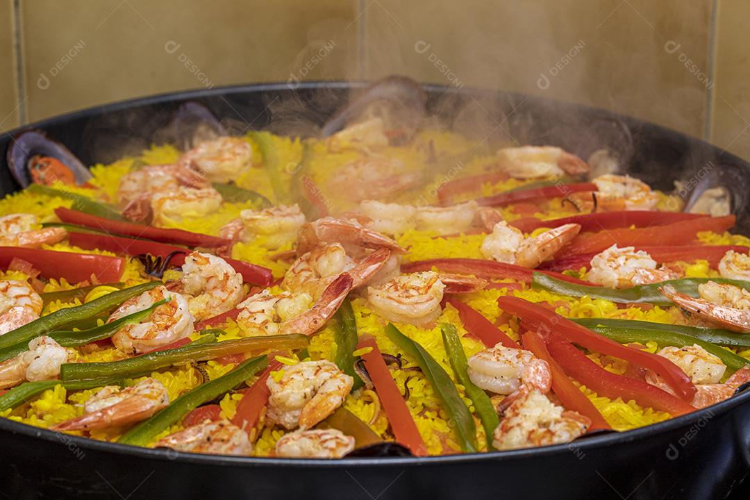 Paelha de frutos do mar tradicional na frigideira em uma mesa de madeira velha Imagem JPG