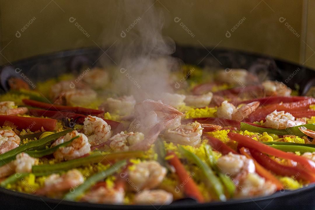 Paelha de frutos do mar tradicional na frigideira em uma mesa de madeira velha Imagem JPG