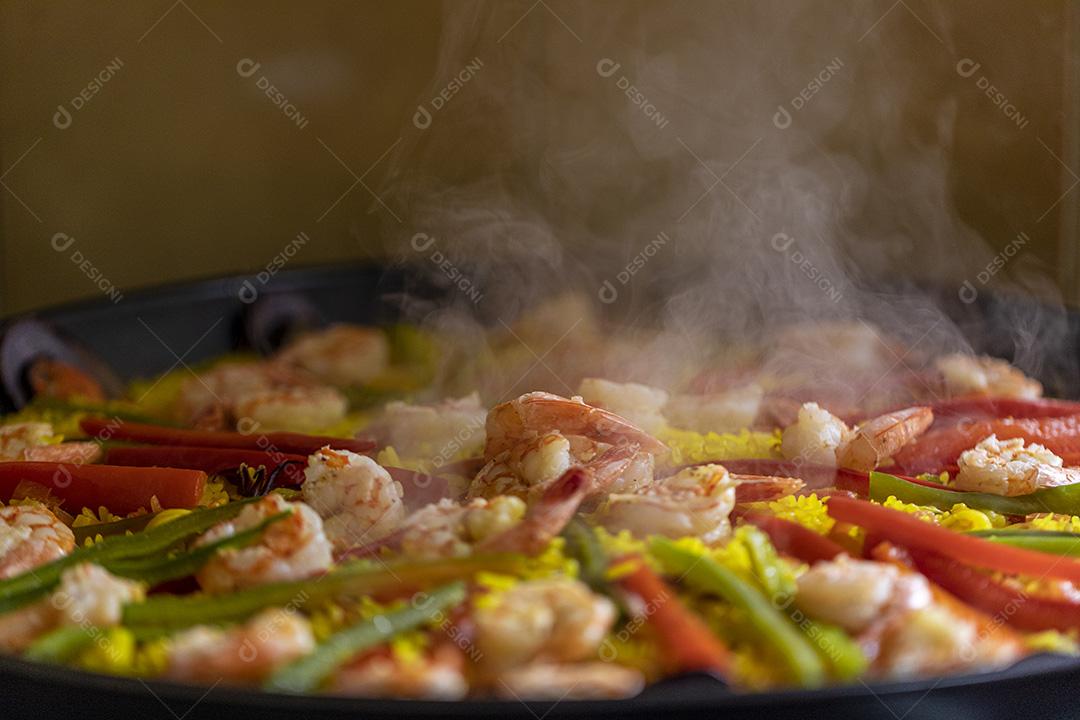 Paelha de frutos do mar tradicional na frigideira em uma mesa de madeira velha Imagem JPG