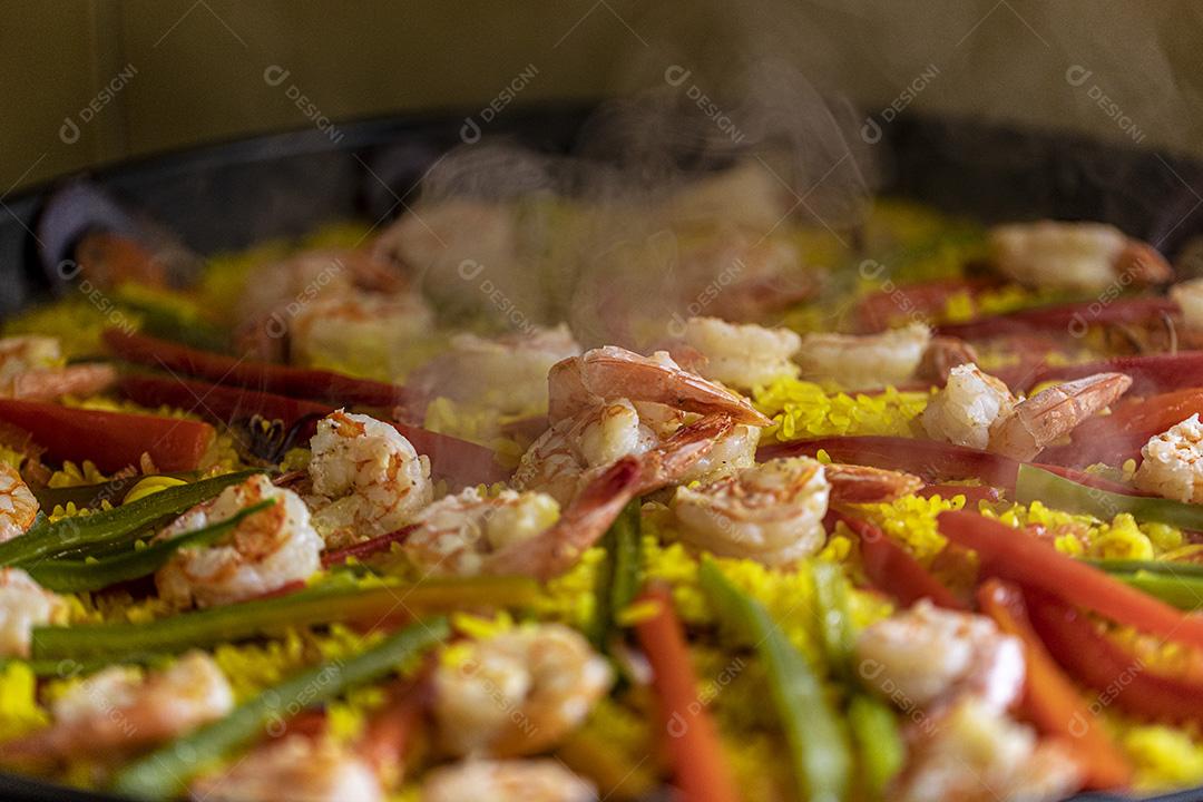 Paelha de frutos do mar tradicional na frigideira em uma mesa de madeira velha Imagem JPG