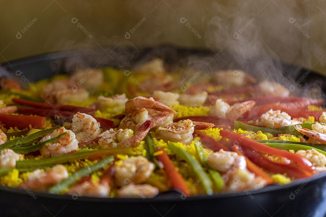Paelha de frutos do mar tradicional na frigideira em uma mesa de madeira velha Imagem JPG
