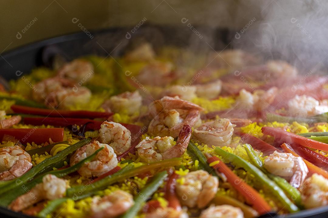 Paelha de frutos do mar tradicional na frigideira em uma mesa de madeira velha Imagem JPG