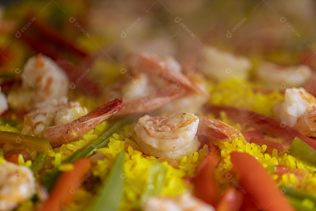 Paelha de frutos do mar tradicional na frigideira em uma mesa de madeira velha Imagem JPG