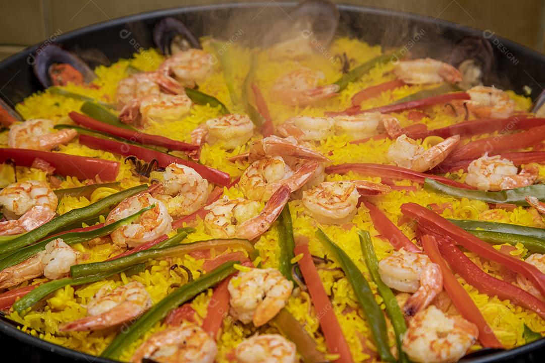 Paelha de frutos do mar tradicional na frigideira em uma mesa de madeira velha Imagem JPG