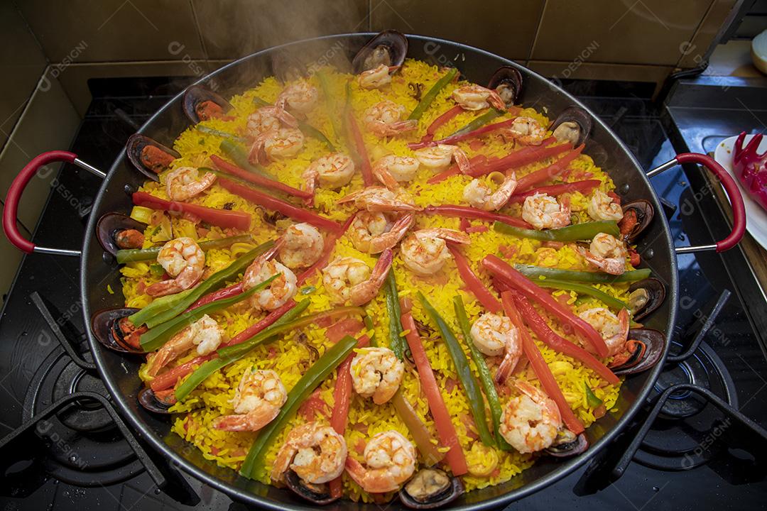 Paelha de frutos do mar tradicional na frigideira em uma mesa de madeira velha Imagem JPG