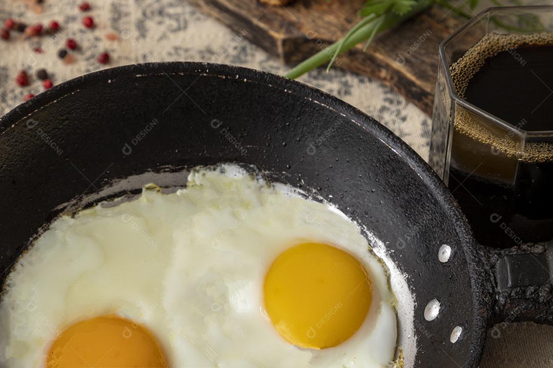 Ovos fritos na panela de ferro e café no café da manhã Imagem JPG