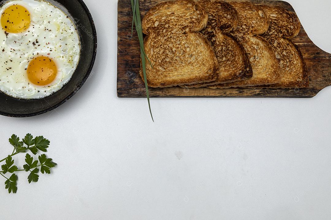 Ovos fritos com salsa em uma panela de ferro rústica, torradas Imagem JPG