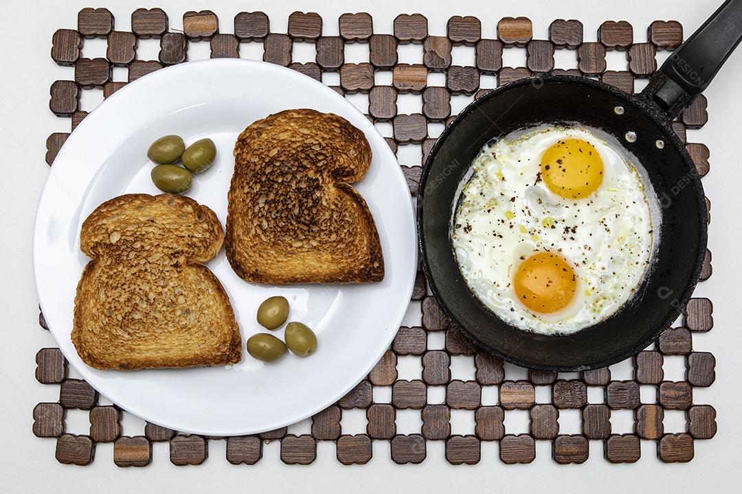Ovos fritos com salsa em uma panela de ferro rústica, torradas Imagem JPG