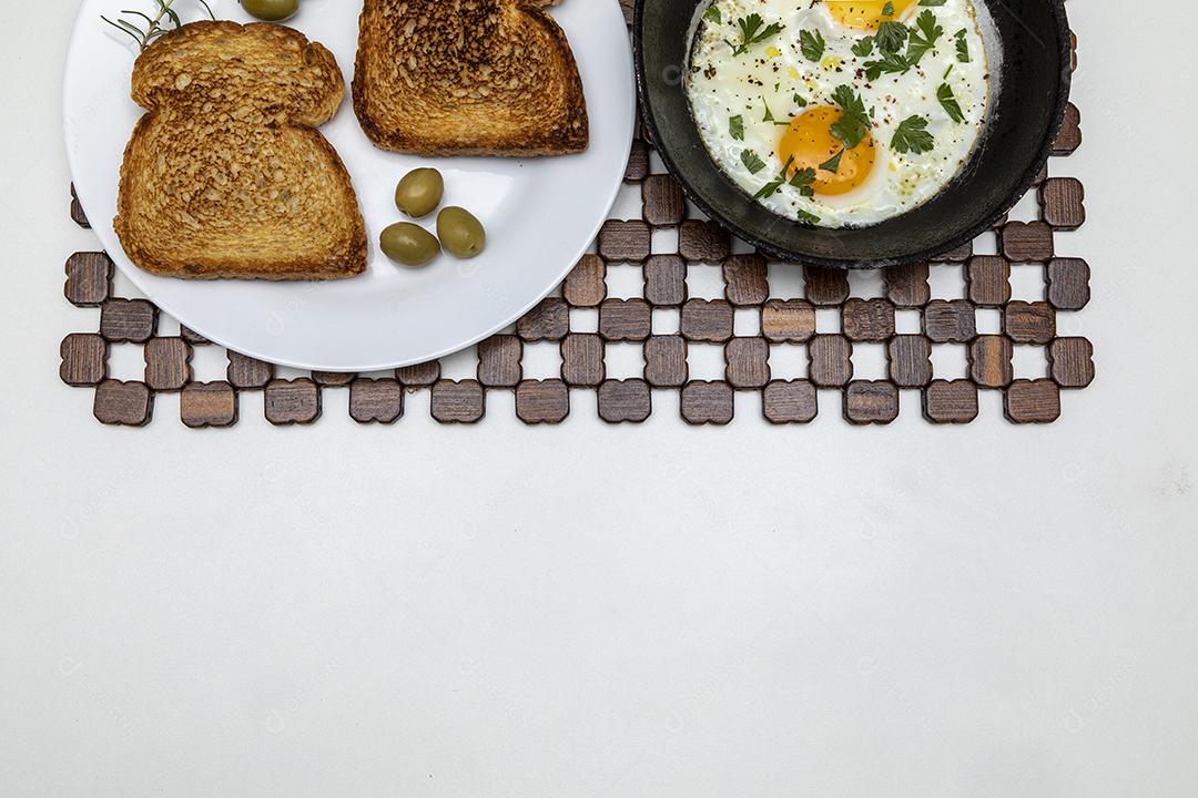 Ovos fritos com salsa em uma panela de ferro rústica, torradas Imagem JPG