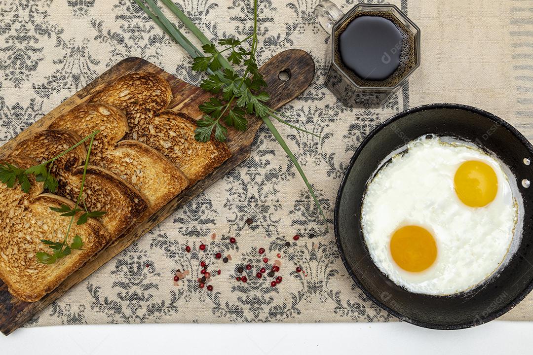 Ovos fritos com salsa em uma panela de ferro rústica, torradas Imagem JPG