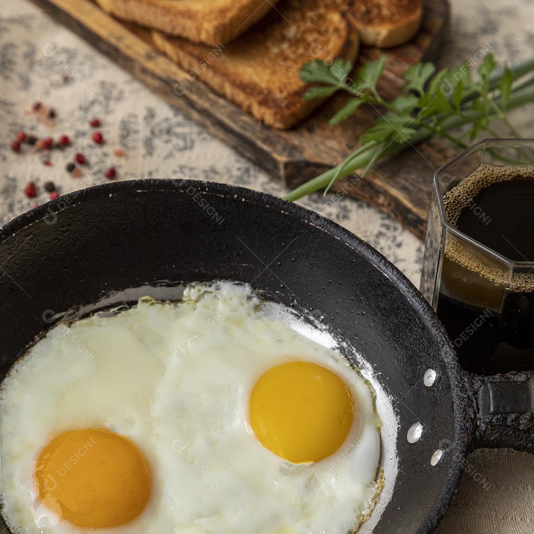 Ovos fritos com salsa em uma panela de ferro rústica, torradas Imagem JPG