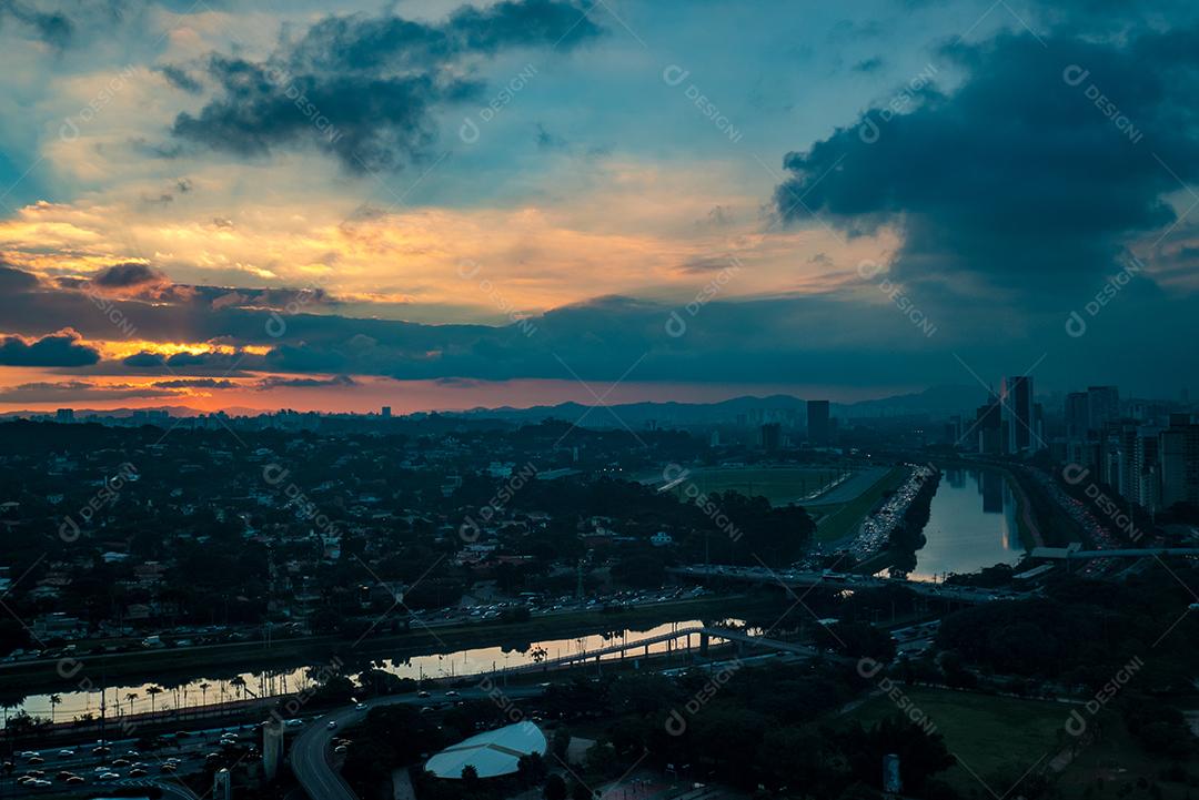 Rio Pinheiros cercado por árvores e escritórios