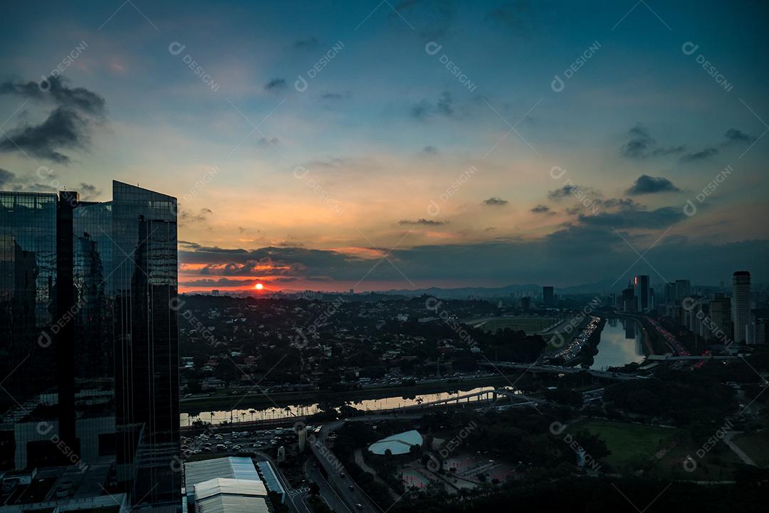 Rio Pinheiros cercado por árvores e escritórios