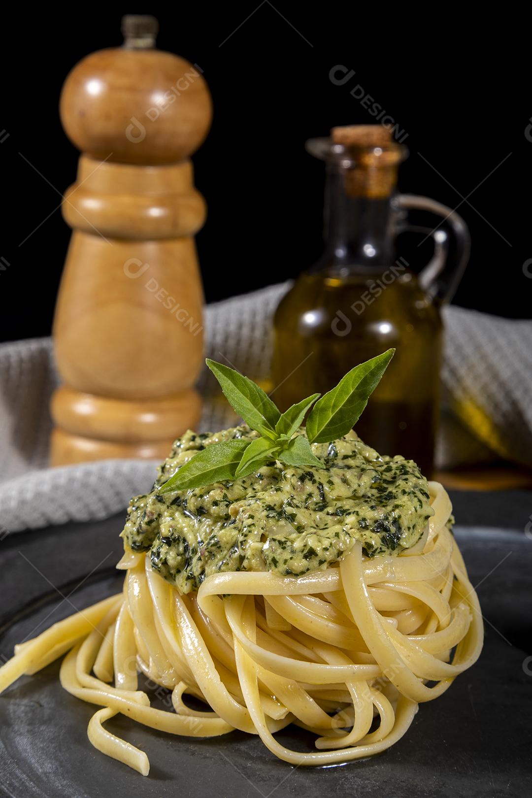 Macarrão Esparguete com molho pesto e folhas de manjericão fresco Imagem JPG