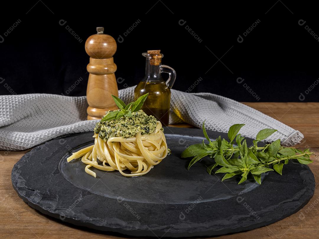 Macarrão Esparguete com molho pesto e folhas de manjericão fresco Imagem JPG