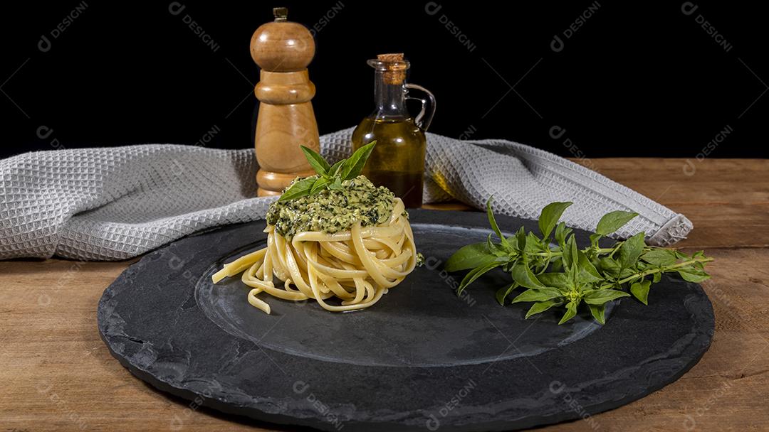 Macarrão Esparguete com molho pesto e folhas de manjericão fresco Imagem JPG