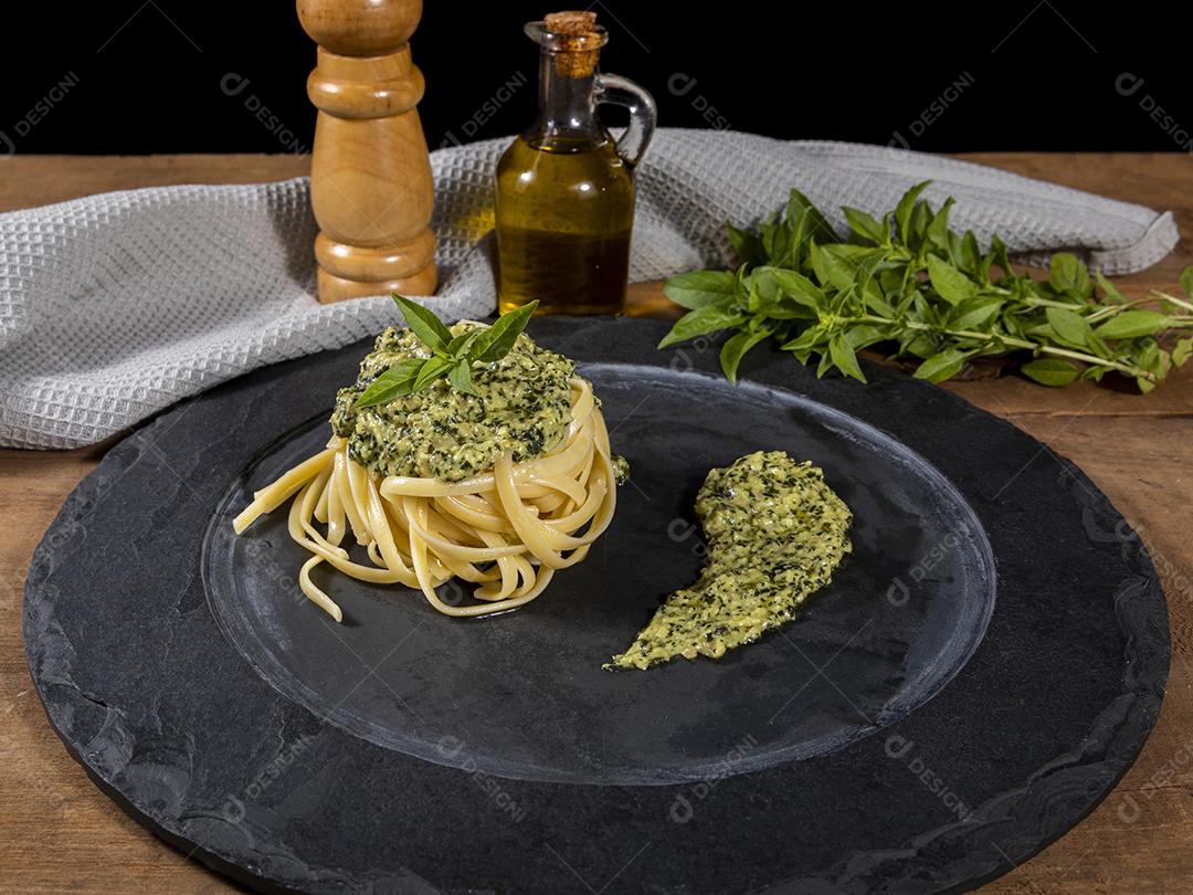 Macarrão Esparguete com molho pesto e folhas de manjericão fresco Imagem JPG