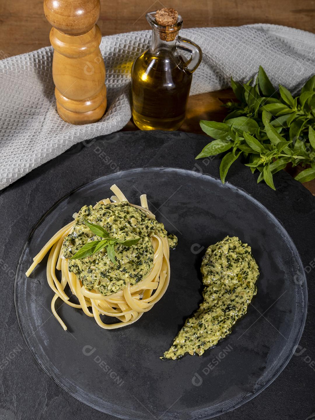 Macarrão Esparguete com molho pesto e folhas de manjericão fresco Imagem JPG
