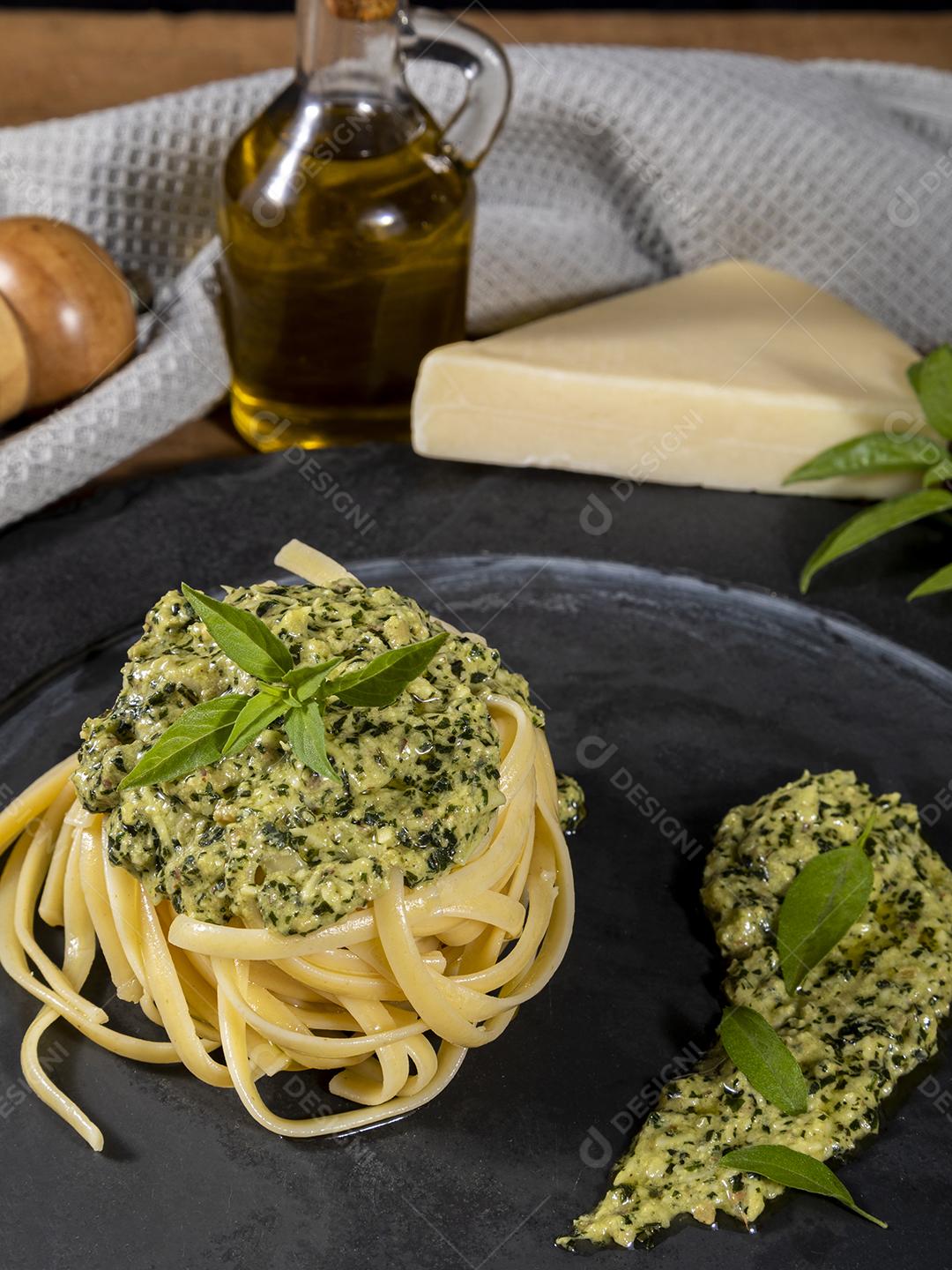 Esparguete de macarrão com molho pesto e folhas de manjericão fresco Imagem JPG