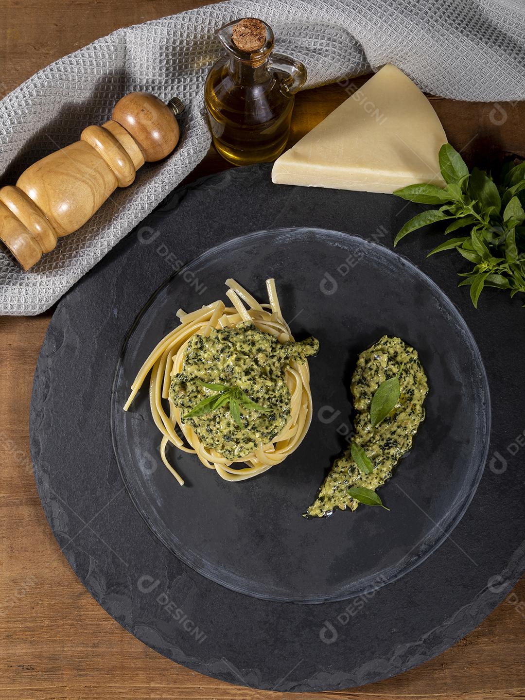 Esparguete de macarrão com molho pesto e folhas de manjericão fresco Imagem JPG