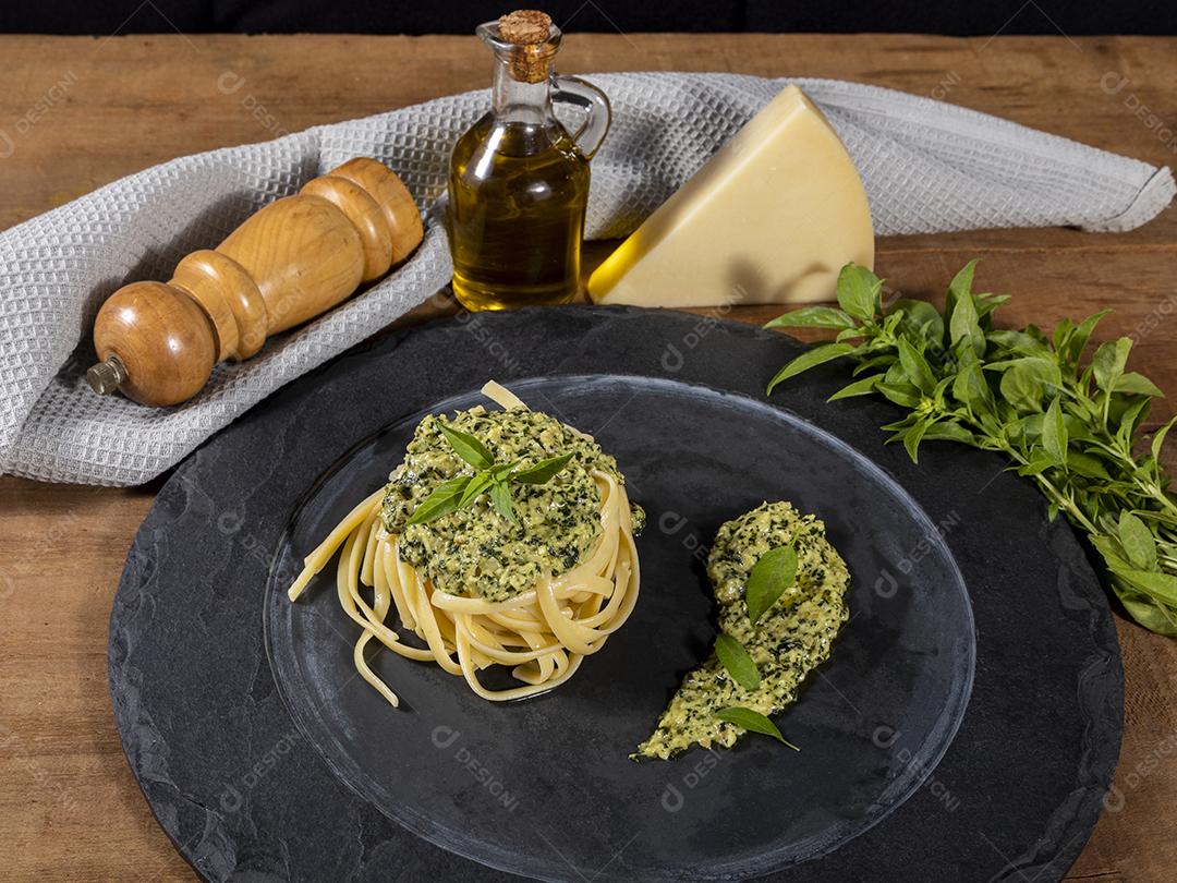 Esparguete de macarrão com molho pesto e folhas de manjericão fresco Imagem JPG