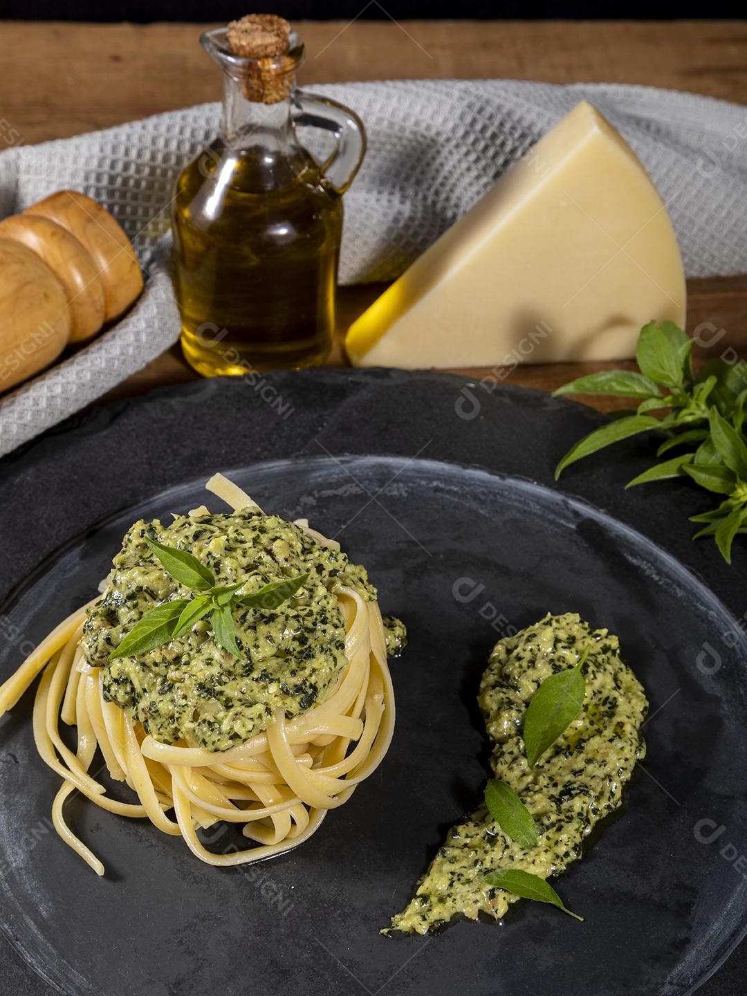 Esparguete de macarrão com molho pesto e folhas de manjericão fresco Imagem JPG