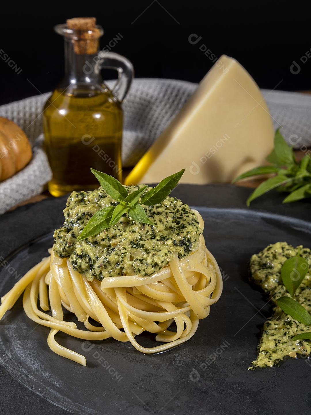 Esparguete de macarrão com molho pesto e folhas de manjericão fresco Imagem JPG