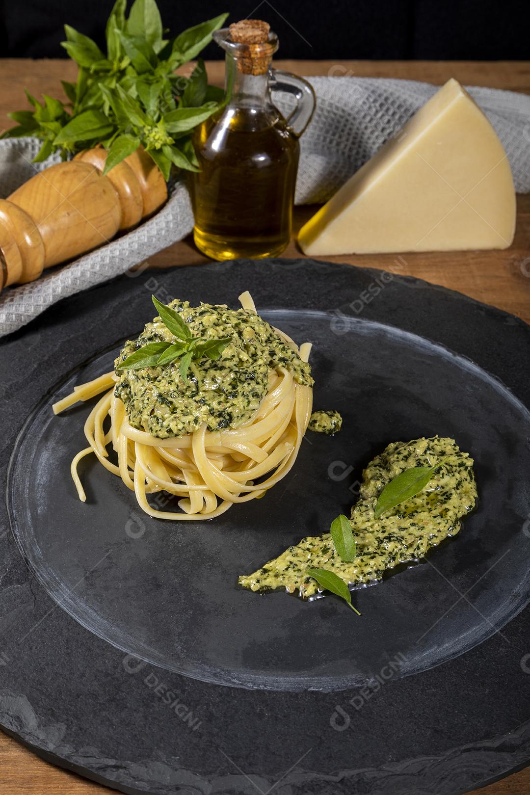 Esparguete de macarrão com molho pesto e folhas de manjericão fresco Imagem JPG