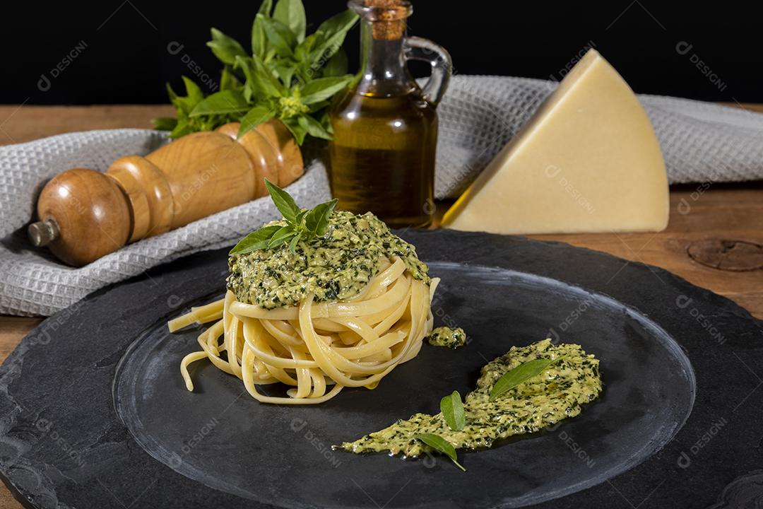 Esparguete de macarrão com molho pesto e folhas de manjericão fresco Imagem JPG