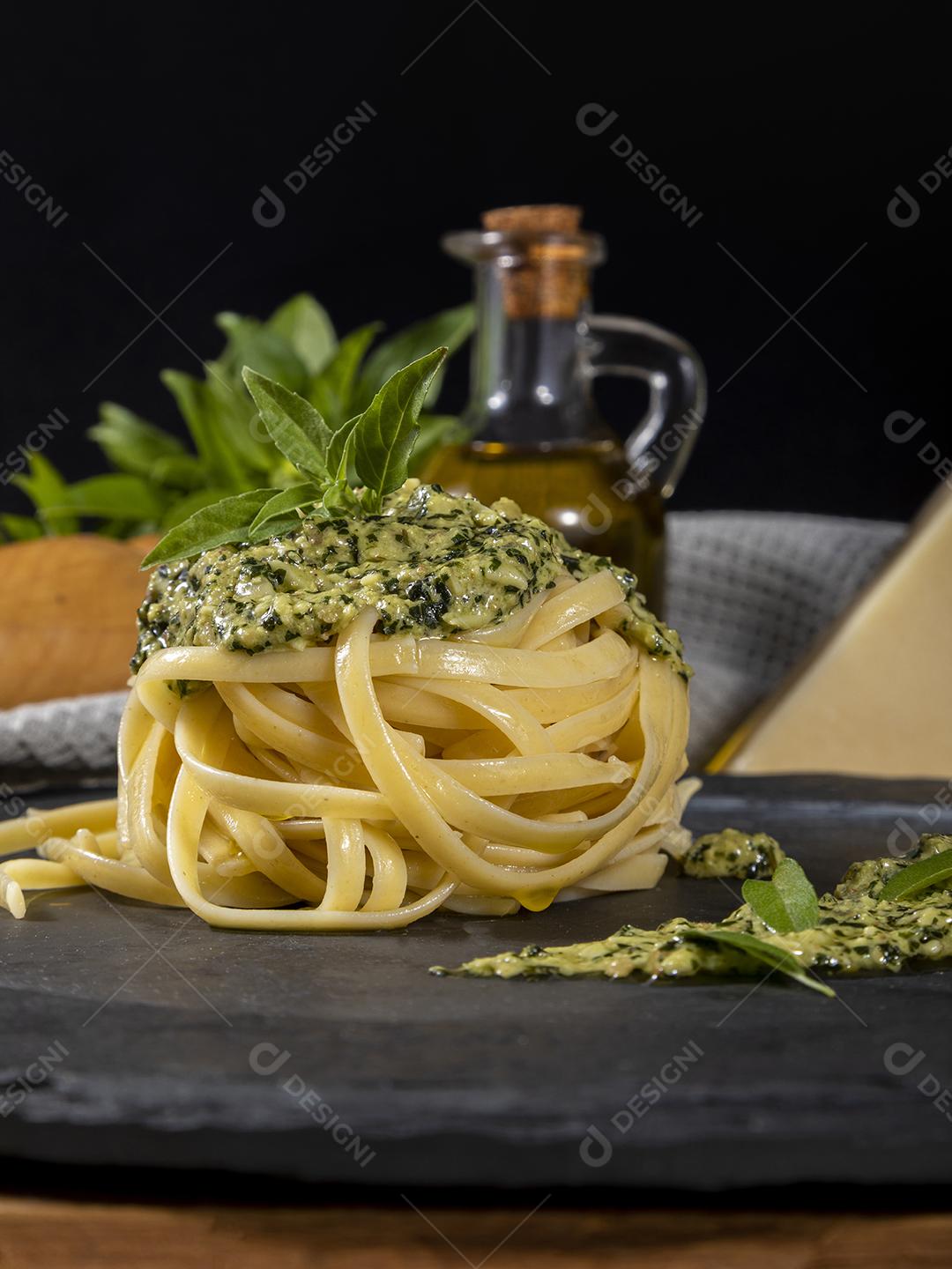 Esparguete de macarrão com molho pesto e folhas de manjericão fresco Imagem JPG