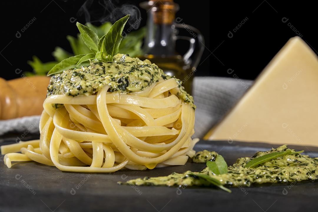 Esparguete de macarrão com molho pesto e folhas de manjericão fresco Imagem JPG