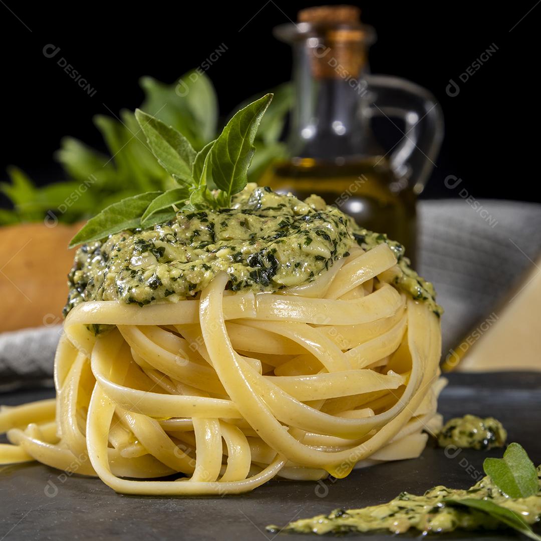 Esparguete de macarrão com molho pesto e folhas de manjericão fresco Imagem JPG