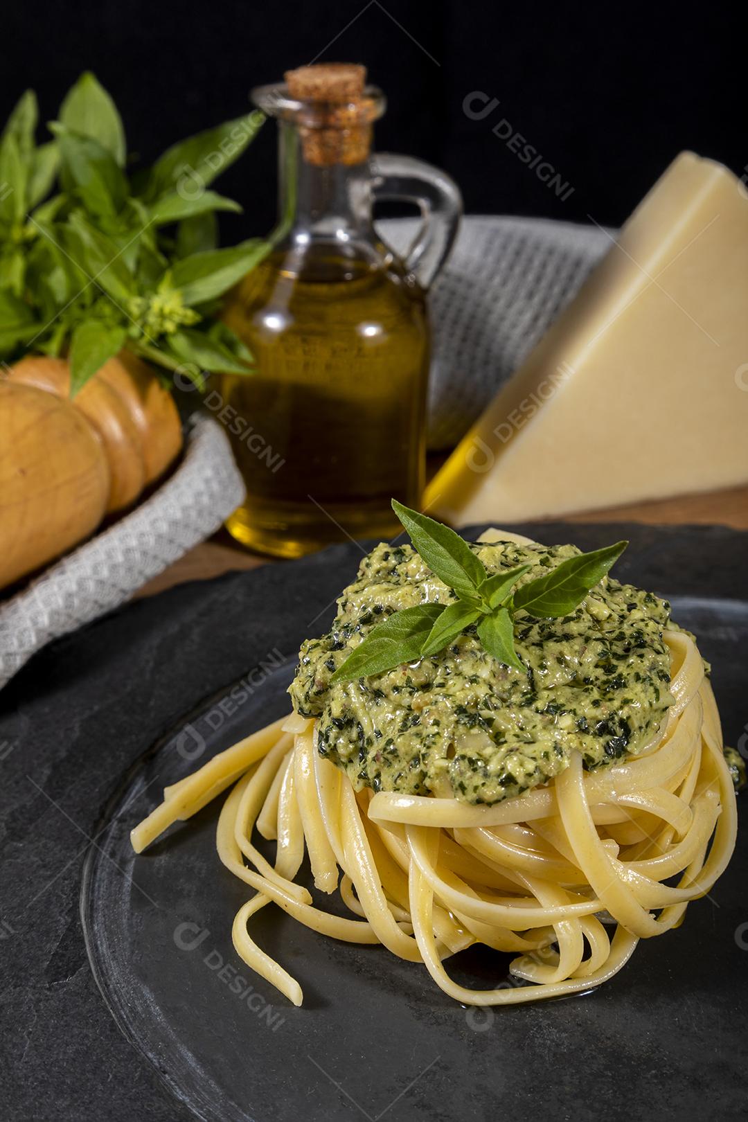 Esparguete de macarrão com molho pesto e folhas de manjericão fresco Imagem JPG