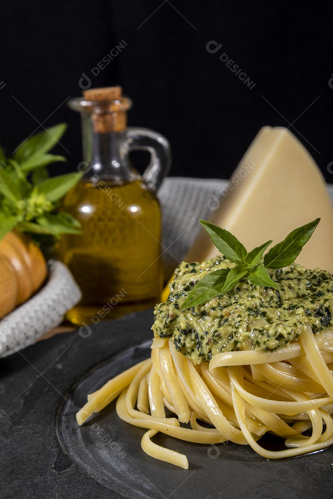 Esparguete de macarrão com molho pesto e folhas de manjericão fresco Imagem JPG