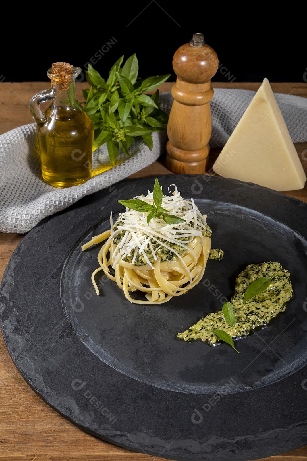 Esparguete de macarrão com molho pesto e folhas de manjericão fresco Imagem JPG