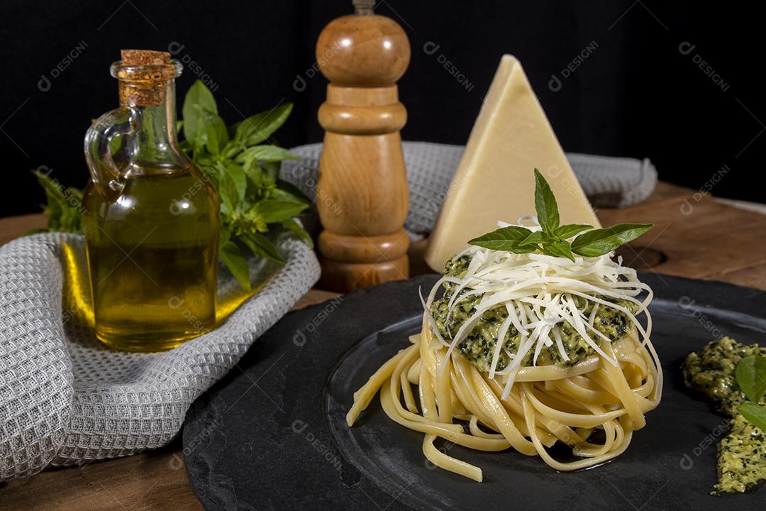 Esparguete de macarrão com molho pesto e folhas de manjericão fresco Imagem JPG