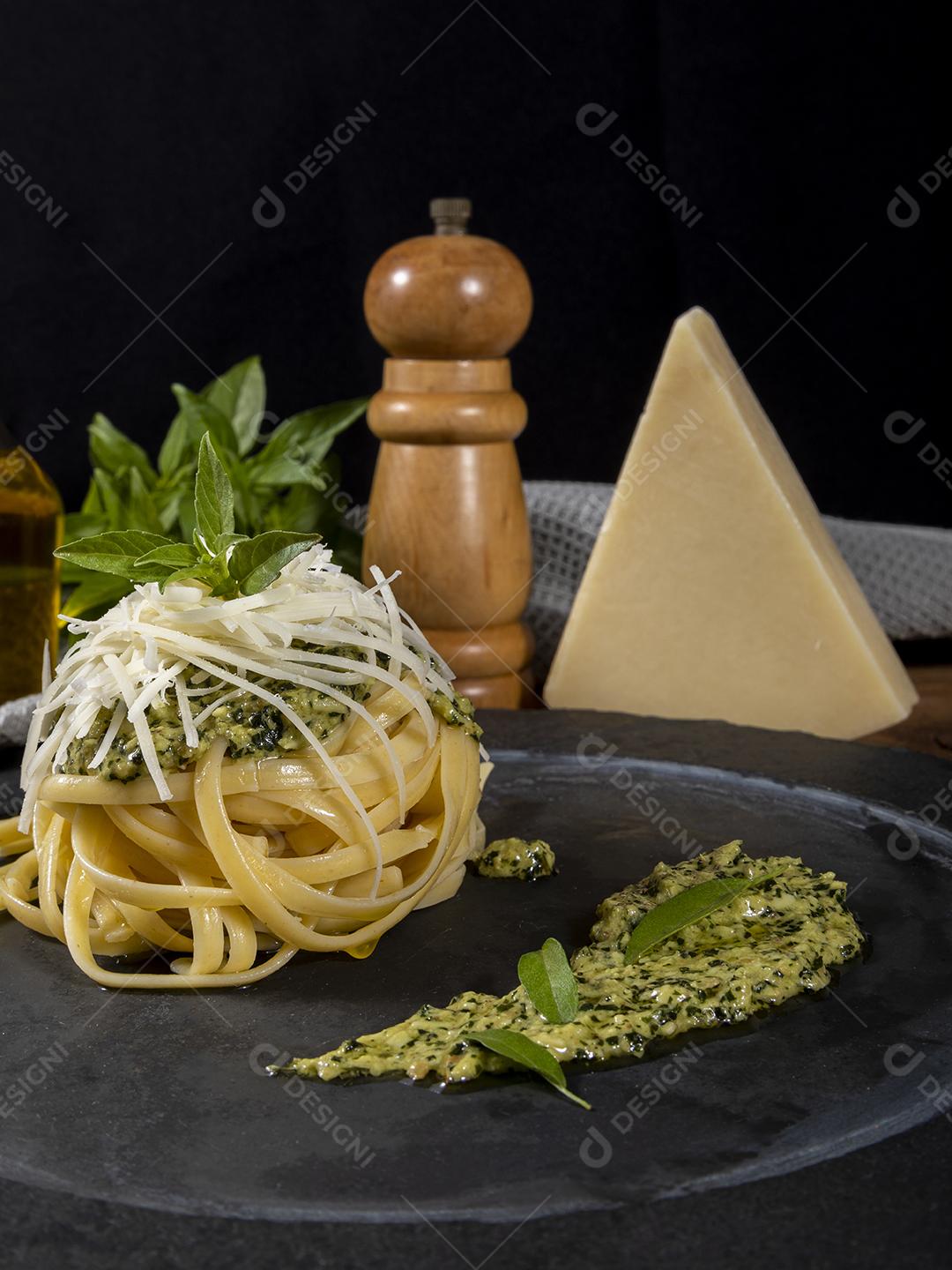 Esparguete de macarrão com molho pesto e folhas de manjericão fresco Imagem JPG