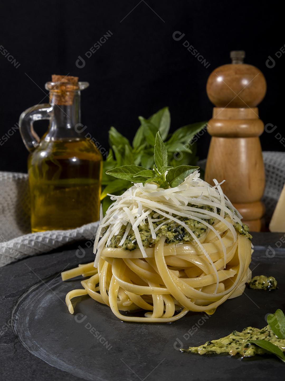 Esparguete de macarrão com molho pesto e folhas de manjericão fresco Imagem JPG