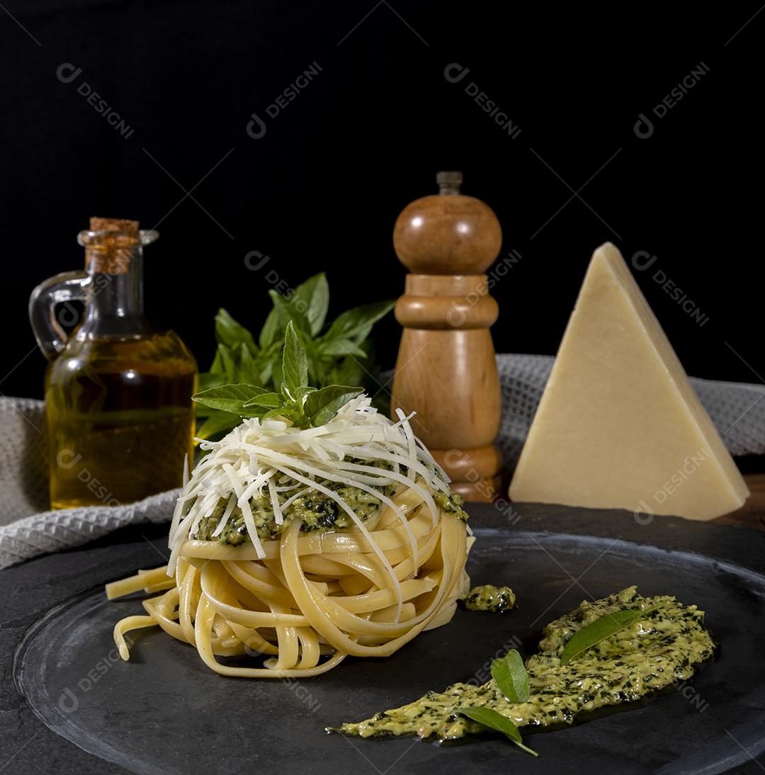 Esparguete de macarrão com molho pesto e folhas de manjericão fresco Imagem JPG