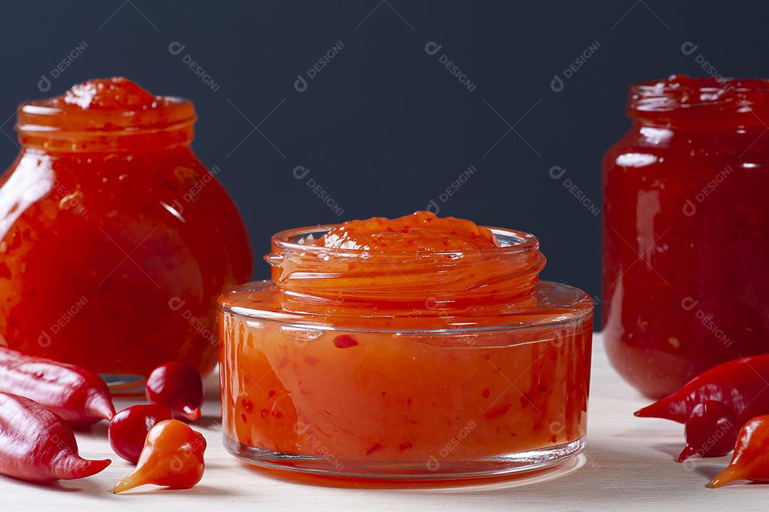 Copos transparentes de geleia de pimenta na mesa de madeira JPG
