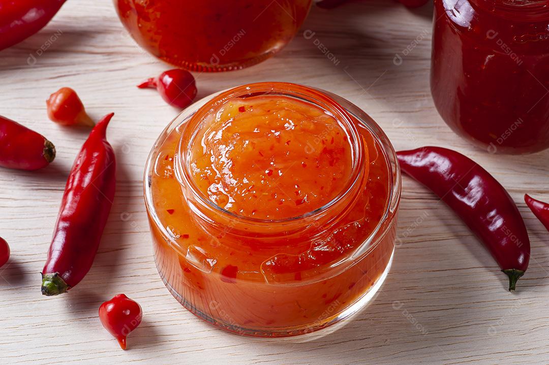 Copos transparentes de geleia de pimenta na mesa de madeira JPG