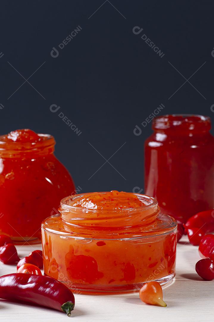Copos transparentes de geleia de pimenta na mesa de madeira JPG